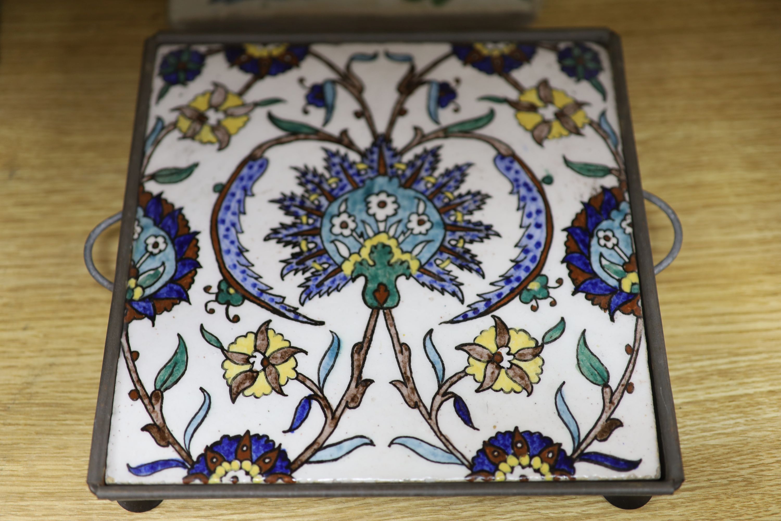 A framed glazed earthenware plaque, a tin glazed tile and one other